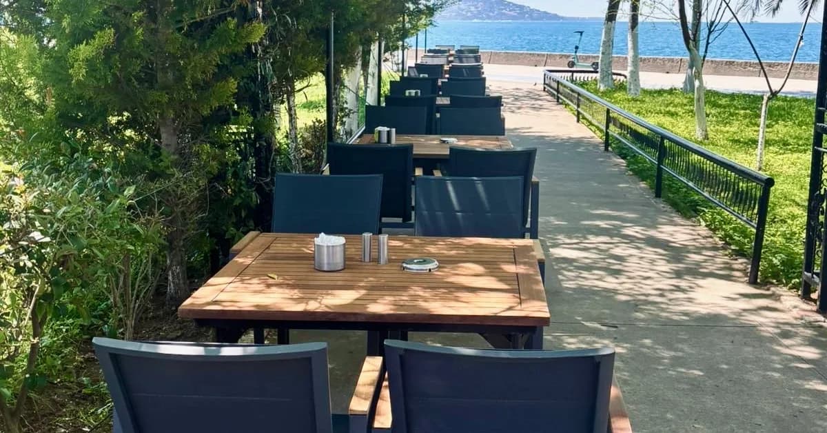 Maltepe'de ağaç gölgesindeki masalar ve Adalar manzarası